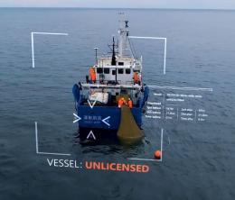 Picture of fishing trawler at sea with computer screen imaged of unlicensed status overlaid