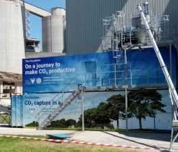 Picture of a cement plant in France with carbon capture and use facility emblazoned with blue banner artwork promoting clean tech ambitions 