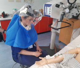 A female doctor wearing the Air-Hood standing next to a dummy patient during a demonstration of the technology at Lewisham and Greenwich NHS Trust.
