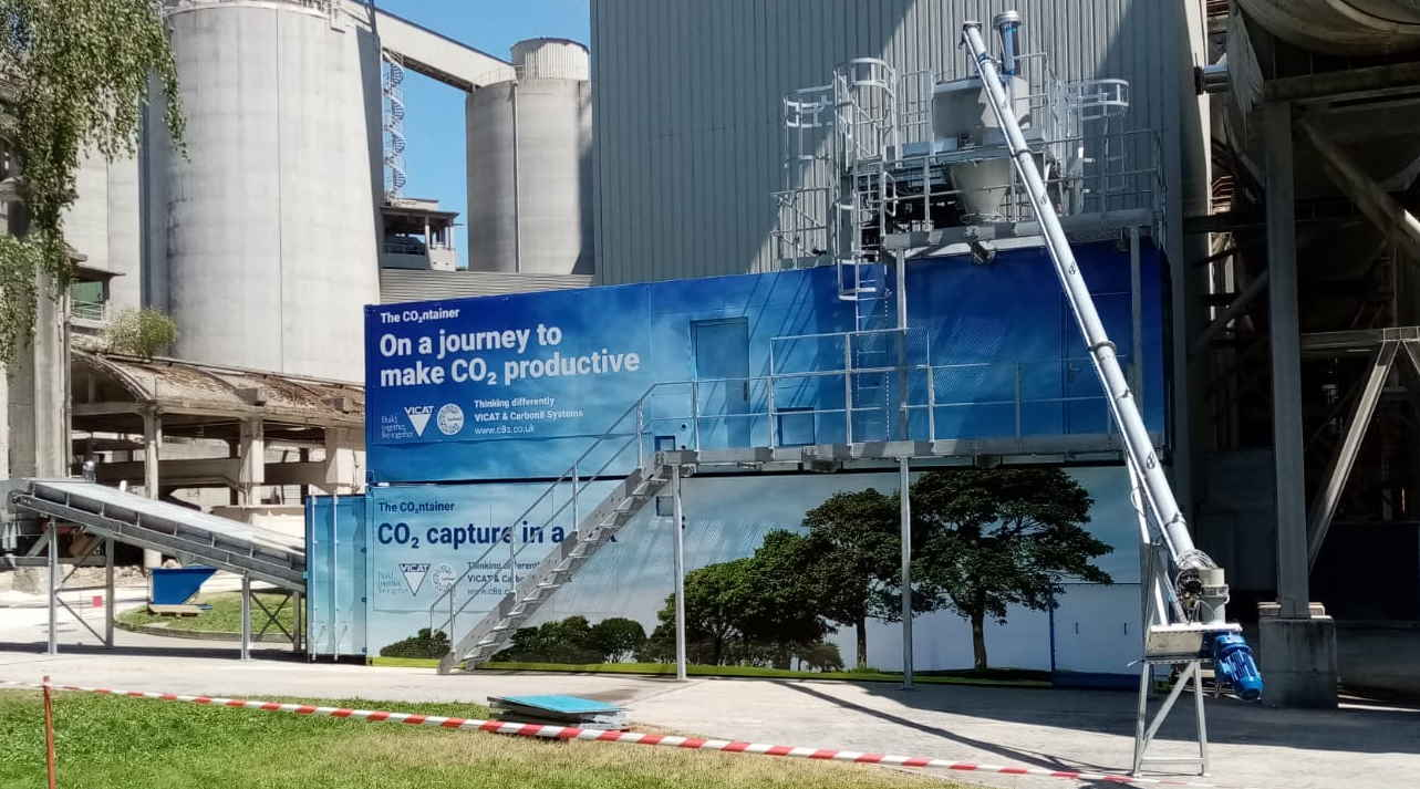 Picture of a cement plant in France with carbon capture and use facility emblazoned with blue banner artwork promoting clean tech ambitions 